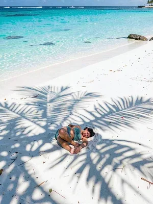 Lagoon turquoise light in Rarotonga, Palm shadow grid falling on a sleeping figu