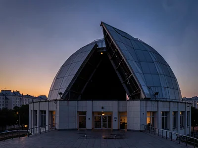 Dome slit open revealing dark interior against dusk sky