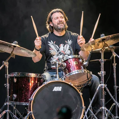Drummer mid-performance, sticks captured eight times between snare hits