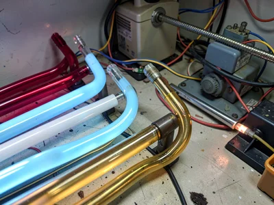 Several glass tubes in a rack sorted by color — ruby, sky blue, white, gold