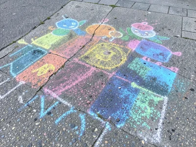 A rain-partially-washed chalk drawing, the colors bleeding and blurring into bea