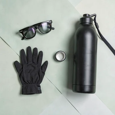 Color-block flatlay of cycling accessories on flat sage paper, eyewear, gloves, 