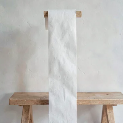 Vertical paper texture of a long roll of polishing paper hanging by a bench