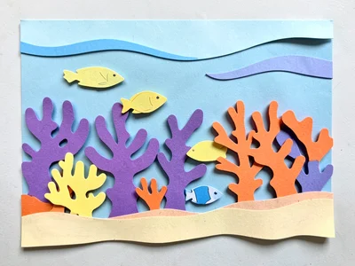 A coral reef from the side: light blue water behind, purple and orange coral for