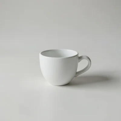 Minimalist photography of a single white coffee cup on a clean matte surface, centered composition, soft natural window 