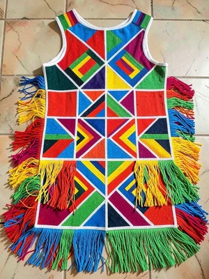 Bride's beaded ceremonial apron flat-lay — layered fringe and geometric panels