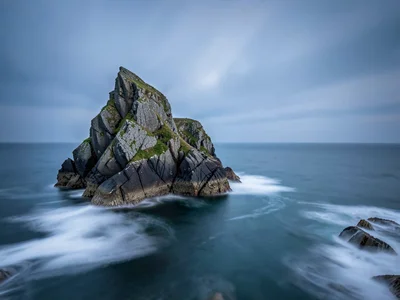 Rock stack surrounded by completely smooth ocean