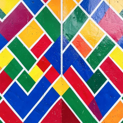 Close-up of painted wall corner — interlocking zigzag triangles in primary color