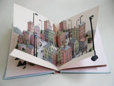 Pop-up book opening to reveal detailed paper cityscape with working paper street