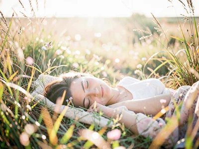 Woman napping in a field of tall grass