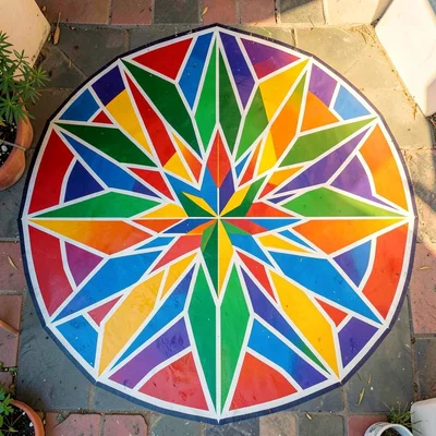 Overhead view of painted courtyard floor — geometric star pattern radiating from