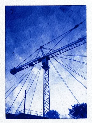 A construction crane against an empty sky with cables radiating from its arm