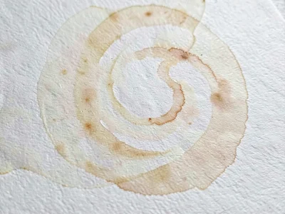 Paste swirl marbling spreading slowly across watercolor cold-press cotton in a p