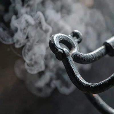 Tight texture study of cast-iron chandelier link with carbon haze, single key li