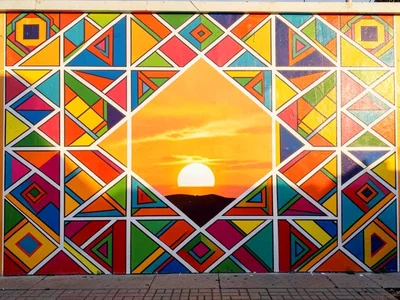 Exterior wall at sunrise — geometric pattern glowing in warm golden light