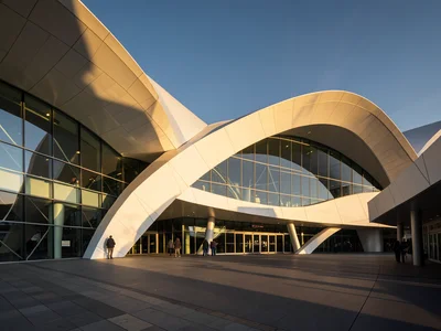 Futuristic train station with sweeping white curves and glass walls