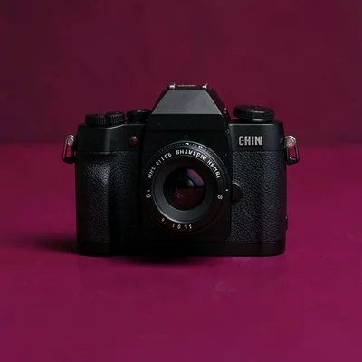 Catalog hero of a single mid-format camera centered on a saturated burgundy back