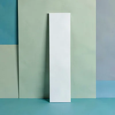 Vertical story-ratio composition of a tall edge restraint piece against a sage-g