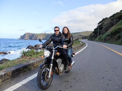 Couple on motorbike on coastal road
