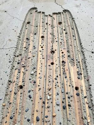 Board-formed concrete with vertical cedar plank impressions, knot holes and grai
