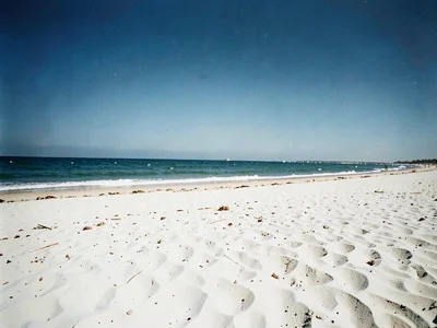 Beach scene at midday with bleached white sand and no shadows