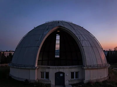 Dome slit open revealing dark interior against dusk sky