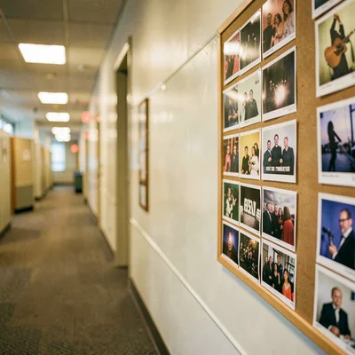 Long office hallway with a bulletin board of song demos blurring into golden bok