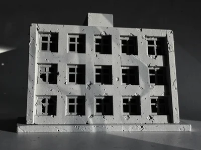 A brutalist apartment slab with twelve windows in a regular grid, raking afterno