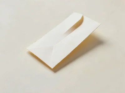 Miniature paper desk holds one oversized folded letter unfolding diagonally acro