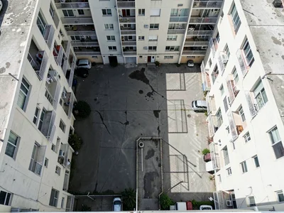 Apartment complex courtyard, identical balconies creating shadow grid