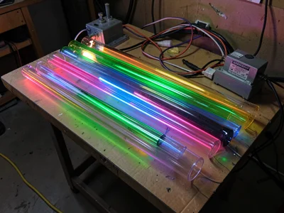 A flat bench with multiple colored glass tubes laid parallel — unlit, just the g