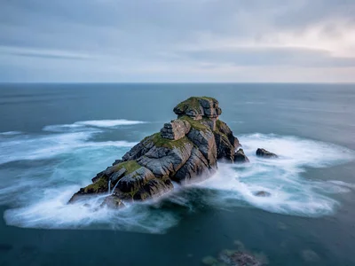 Rock stack surrounded by completely smooth ocean