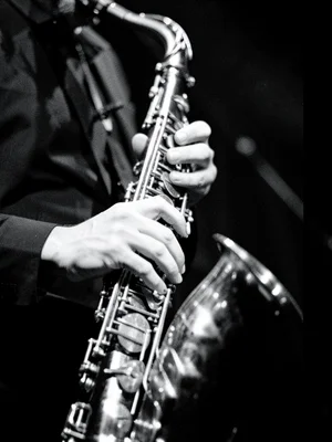 A jazz musician's hands on saxophone keys, fingers blurred with motion, the inst