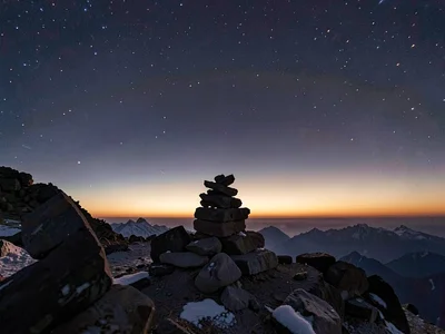 Summit cairn silhouetted against the thin air gradient toward space