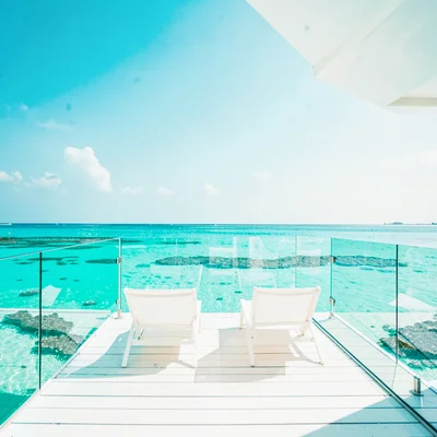 Expansive turquoise negative space, bleached whites, An empty overwater bungalow