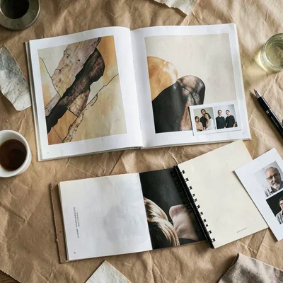 A photographer-portfolio overhead-table spread with abstract prints, contact-she