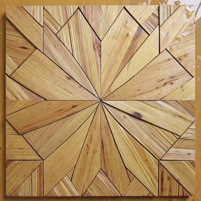 A straw panel with a pinwheel motif — triangular sections of straw radiating fro