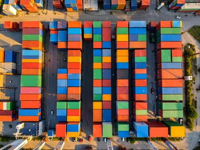 A container ship port from above, the grid of colored containers — red, blue, gr
