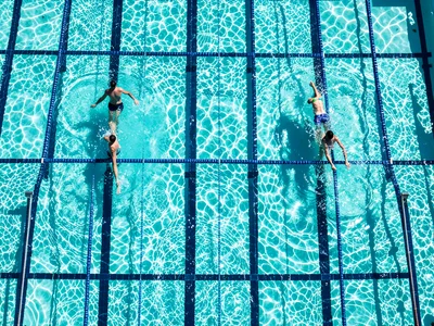 Lap swimmers in adjacent lanes, each at a different point in their stroke, lane 