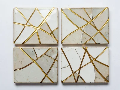 Set of repaired ceramic tiles arranged as mosaic — gold lines forming an abstrac
