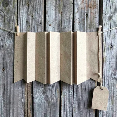 Wide kraft-paper banner pinned across a weathered timber wall, deep accordion fo