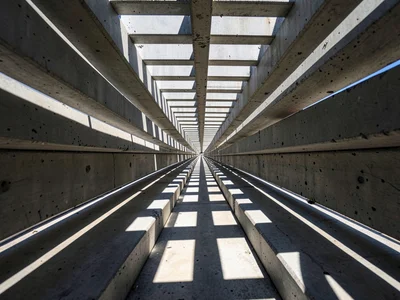 Tightly cropped concrete brise-soleil grid receding to a single vanishing point,