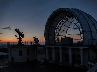 Telescope pier silhouette visible through open dome