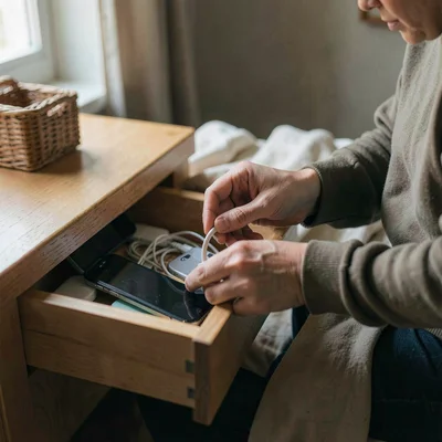 Soft natural light photograph, Person unplugging devices before bedtime, phone g