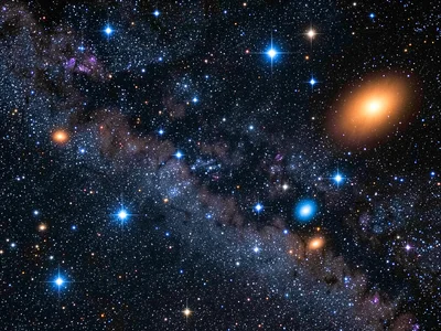 An open star cluster with hot blue-white main sequence stars and a few orange-re