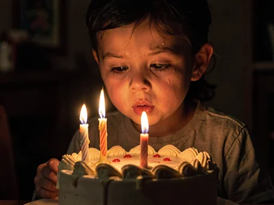 Birthday cake candles lighting child's face, the anticipation before the wish-br