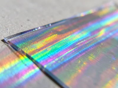 Mica sheet edge-on, thin crystal layers creating vivid color banding like geolog