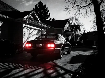 Car backing out of driveway, brake lights glowing red, mysterious departure at d