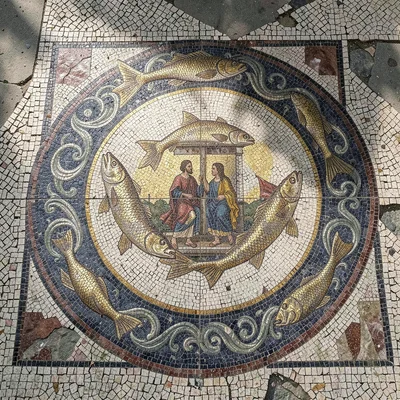 An aerial view of a Roman floor mosaic medallion — fish and wave border surround