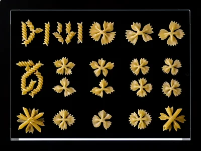 Dried pasta shapes arranged in grid on scanner, different types: fusilli, penne,
